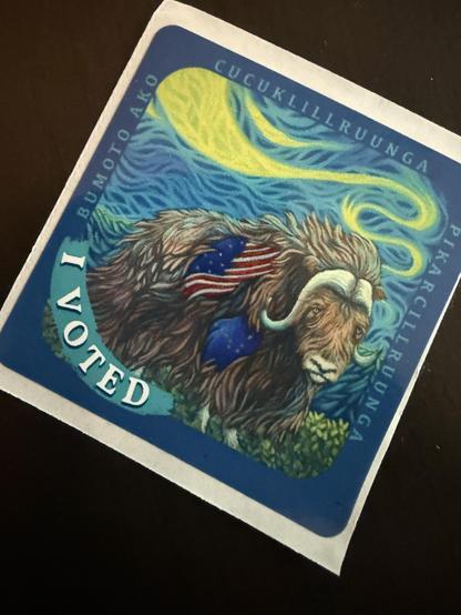 One of the Alaskan "I Voted" stickers this year.  Colorful yellow, green, blue and brown Poster art of a MuskOx with an American and Alaskan flag on its side.
